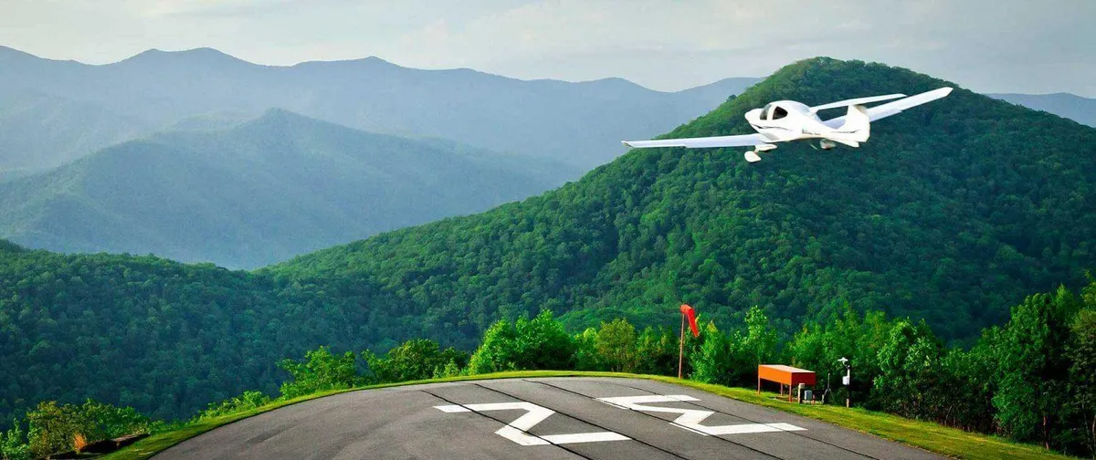 An exterior view of an airplane on a runway with a mountain range as a backdrop. The scene captures the excitement of being near an airstrip, tying in the unique aspect of watching private jets and having quick access to adventures from the resort locale.